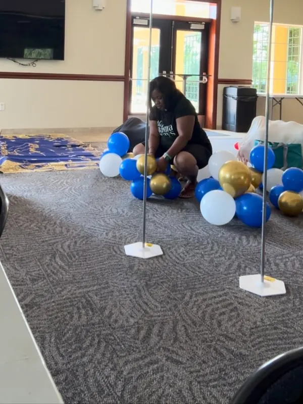 Building blue, white and gold balloon decor on site at a Tampa Bay event venue, CAJE Creations behind the scenes