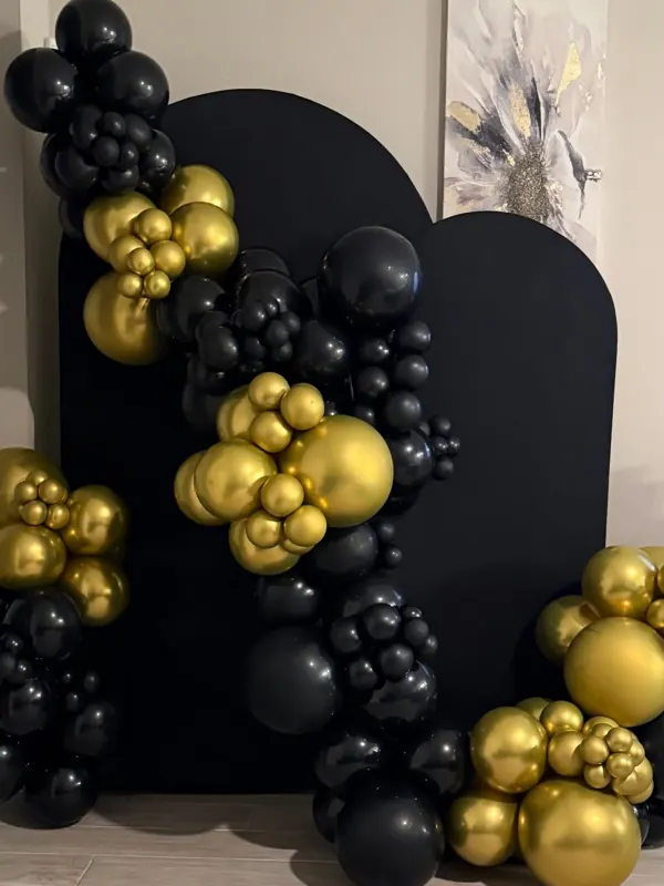 Black and gold organic balloon garland on a black arch backdrop by CAJE Creations, Tampa FL